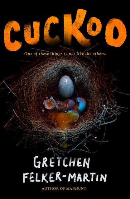 A bird's nest with one intact egg and several broken, colorful eggs.