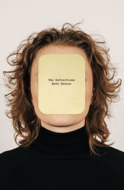 A person's face is covered by a yellow card with "The Definitions Matt Greene" printed on it.