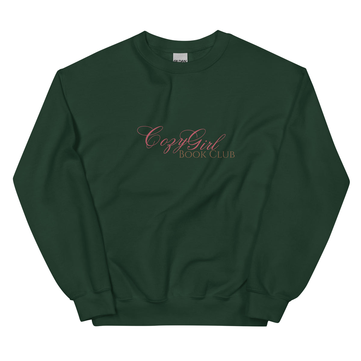 A dark green sweatshirt with "Cozy Girl Book Club" embroidered in pink script.