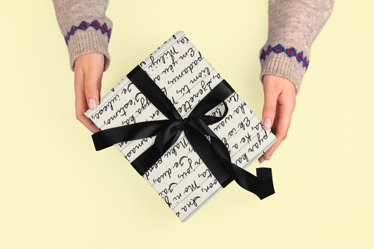 Gift wrapped in paper with handwritten script and black ribbon.